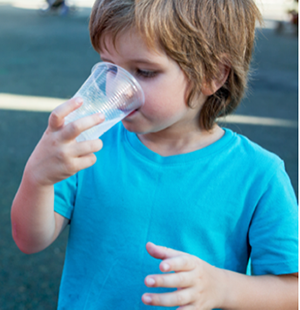 Boy wearing a blue t-shirt drinking water from a plastic cup