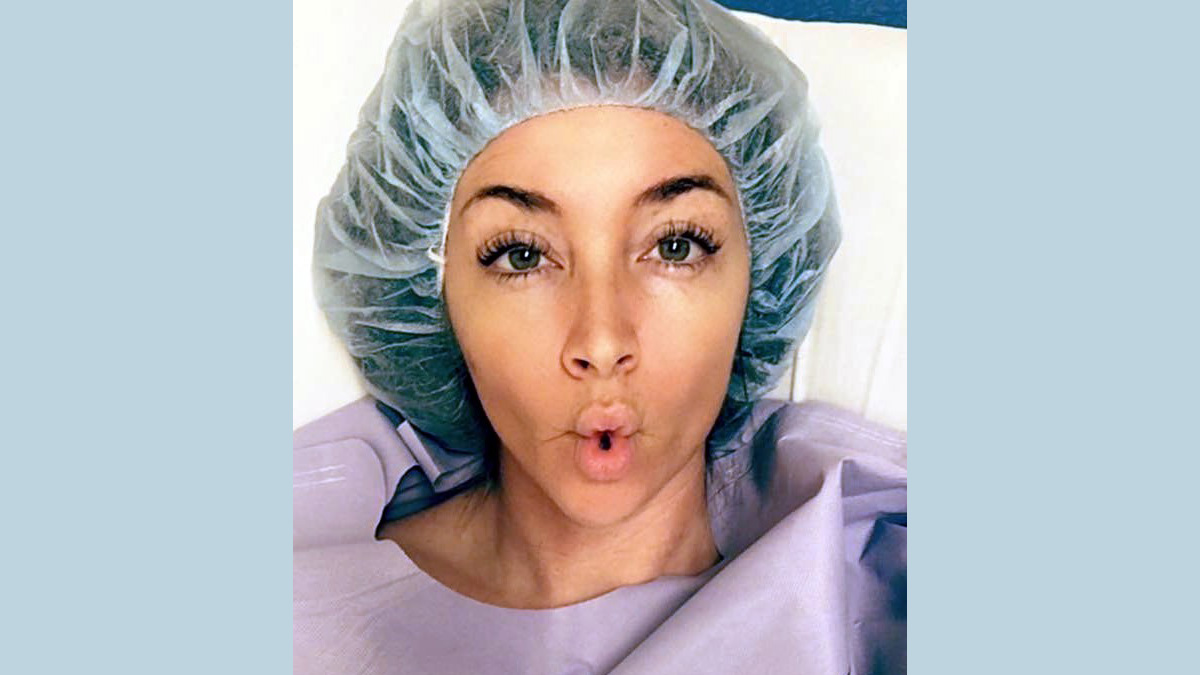 Close-up view of young woman wearing surgical cap and gown