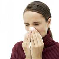 woman sneezing from having seasonal flu