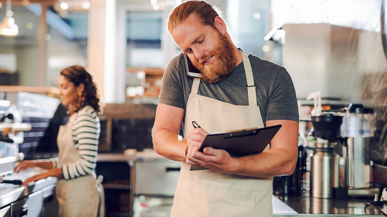 Man with clipboard in cafeteria.
