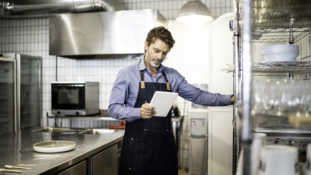 Man monitoring inventory in kitchen