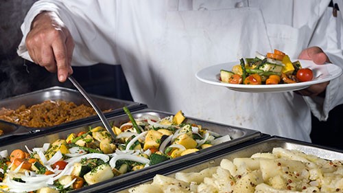 Chef serving a plate of vegetables.