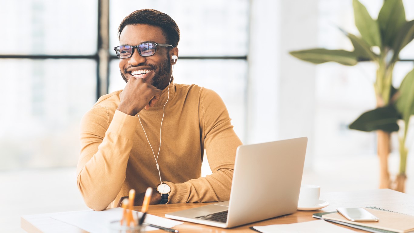 Smiling man in office with laptop computer.