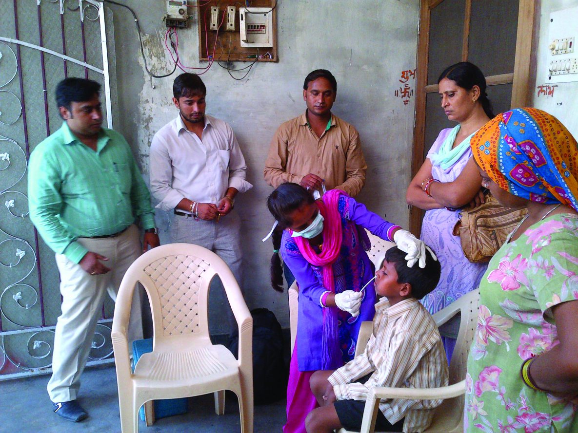 Project staff taking respiratory specimen for influenza testing