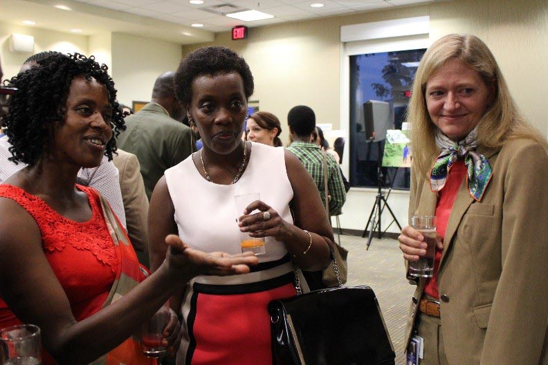 'Jacqueline' explains one of the photos to Ambassador Barks-Ruggles and Hon. Minister Gashumba during the HIV partnership event. Photo Courtesy of W. Herkewitz/USAID Rwanda.