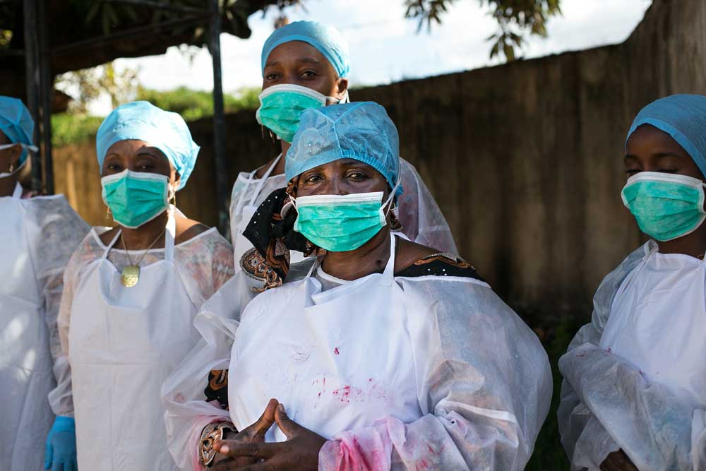 Public health workers learn how to use personal protective equipment at a CDC facilitated training in Guinea. (Photo credit: Patrick Adams/RTI International)