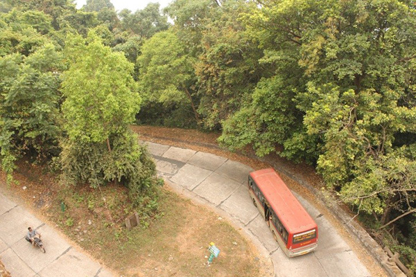 A bus winds its way up a hilly road in Western Ghat.