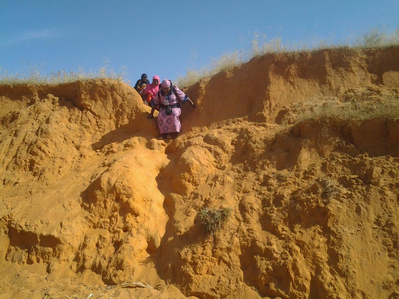 A Nigeria FETP resident and two data collectors hike down extremely difficult terrain to reach underserved settlements.