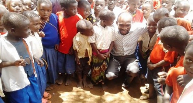 Disease detective John Gwakisa with pupils from  Kajana primary school, March 2017