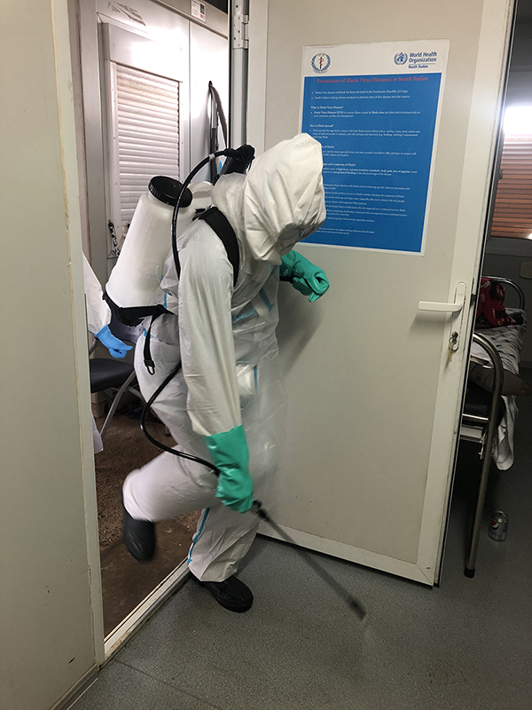 A member of the International Medical Corps disinfecting the area in an Ebola isolation facility where a “suspect” Ebola patient had entered. Photo by Aimee Summers