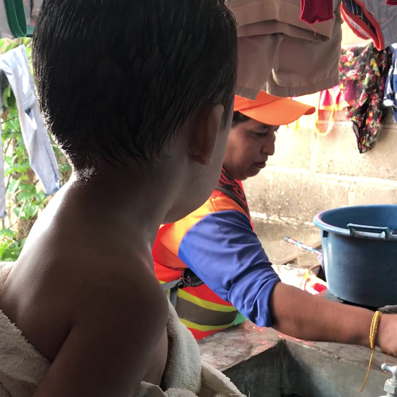 Un voluntario local de la comunidad inspecciona las fuentes abiertas de agua en una residencia privada. Fotografía de:  Jahn Jaramillo