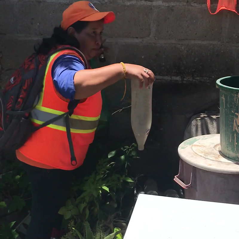 Una voluntaria local de la comunidad inspecciona una residencia privada en busca de contenedores abiertos de agua. Fotografía de: Jahn Jaramillo