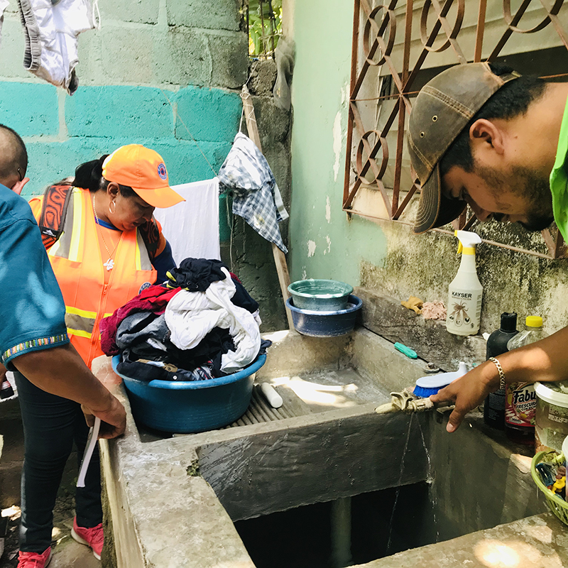 Local community volunteers and MOH staff check for mosquito larvae in open water sources. Photo credit: Jahn Jaramillo