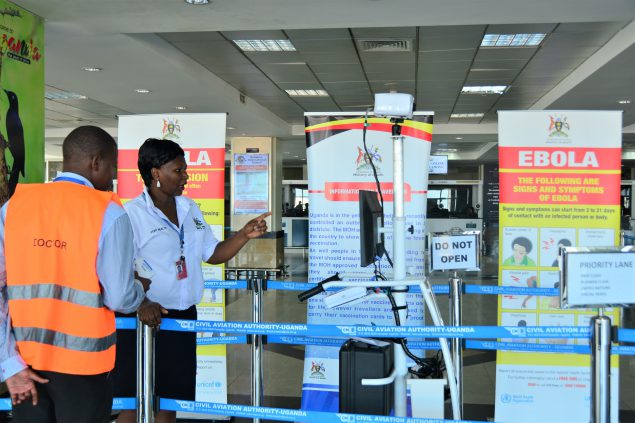 Port health staff looking at a "sick" person standing in line at the airport during the simulation exercise. Photo credit: Irene Nabusoba