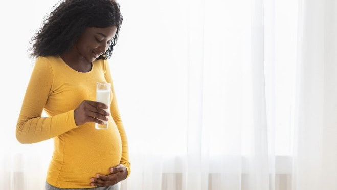 pregnant woman holding glass of milk