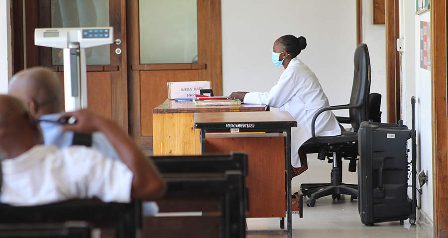 A health care provider attending clients at a care and treatment clinic at Amana Hospital.