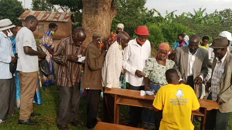 A social worker at the Gema Church in Uganda’s Mityana District verifies the names of these older people