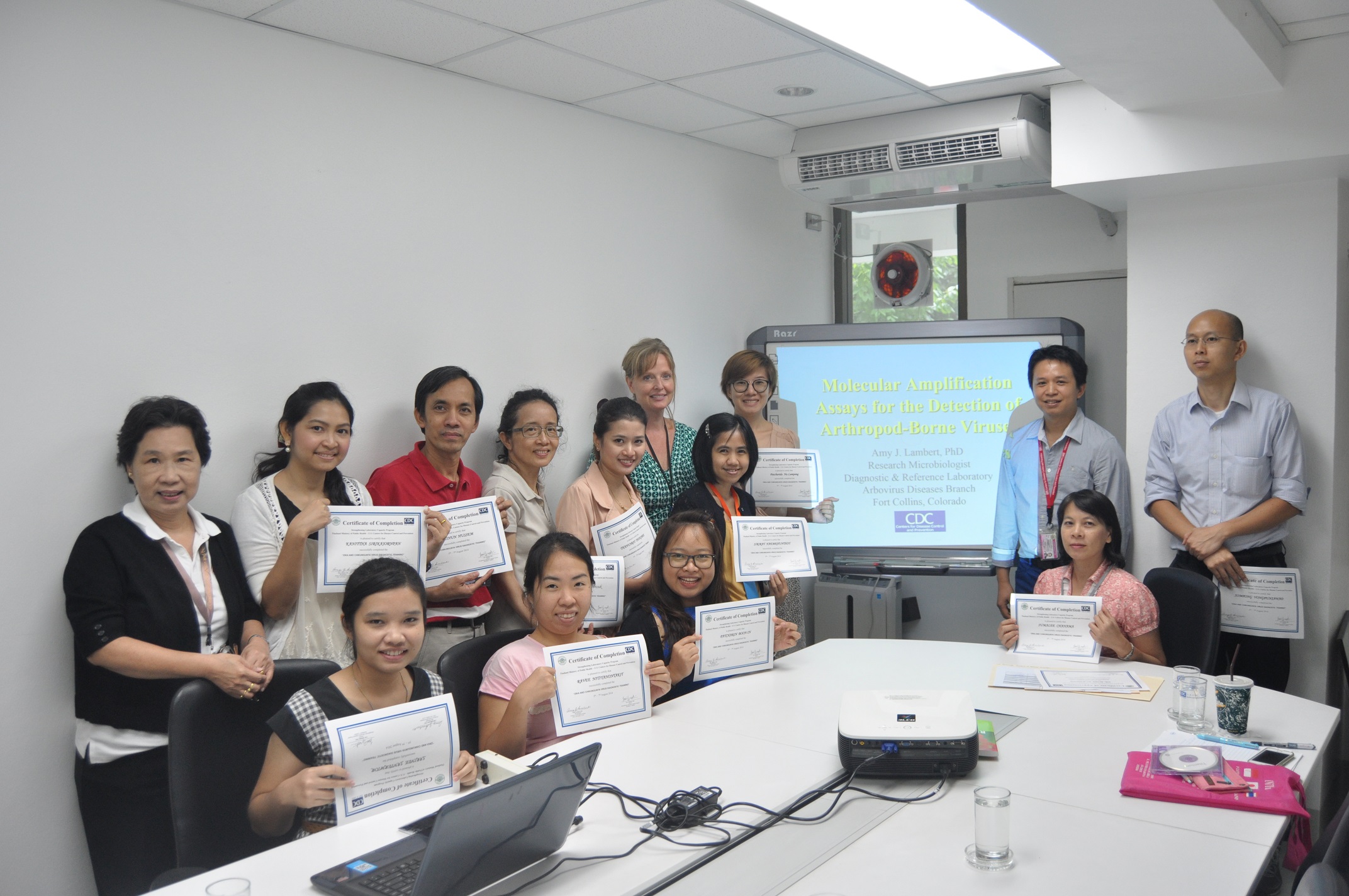 Laboratory workers from the National Institute of Health and Chulalongkorn University display certificates after successfully completing a training on how to identify Zika and Chikungunya viruses.