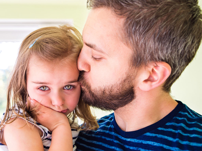 Man embracing crying child