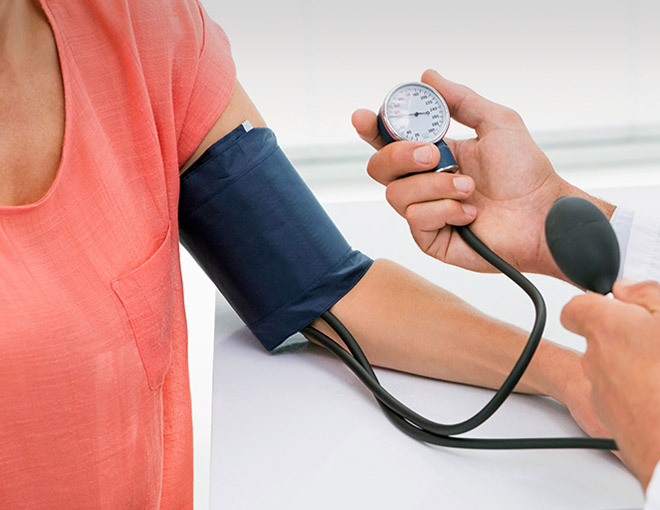 Doctor taking woman's blood pressure