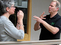 Photo of two people signing.