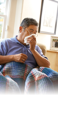 man coughing into tissue