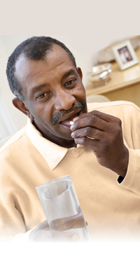 man taking medicine with a glass of water