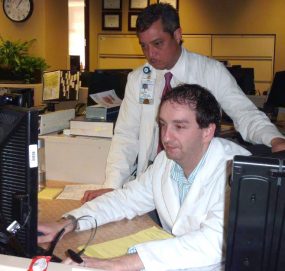 two scientists analyzing data at a computer