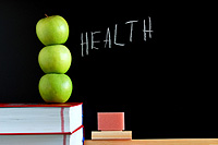 apples stacked on books on a desk