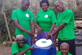 a group of men and women showcasing a portable toilet