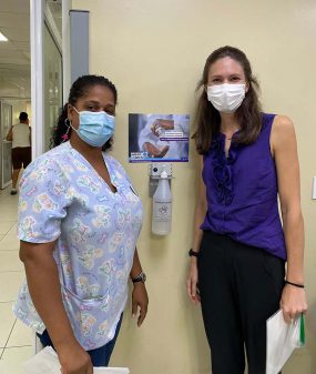 Two women with hand hygiene poster and new ABHR dispenser