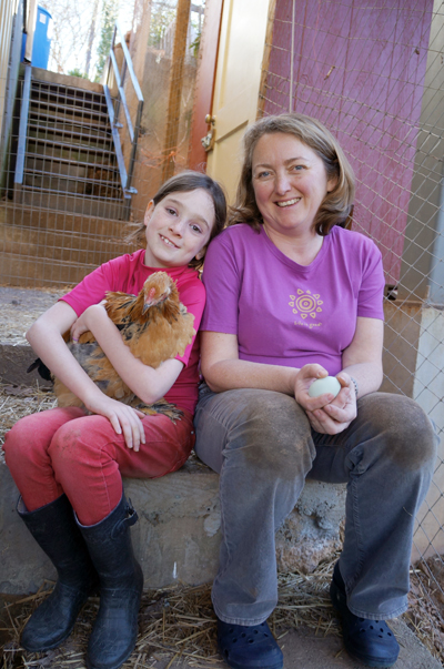 Young girl with her mom holding a hen