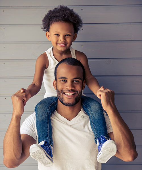 A father holding his son up on his shoulders