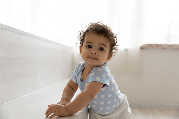 Baby holding furniture while taking first steps