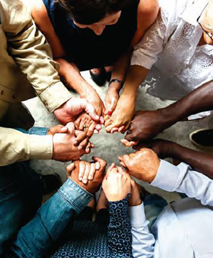 Diverse people holding hands in a circle