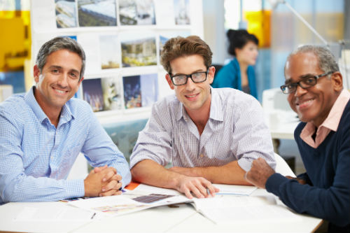 Diverse men sitting at a table smiling