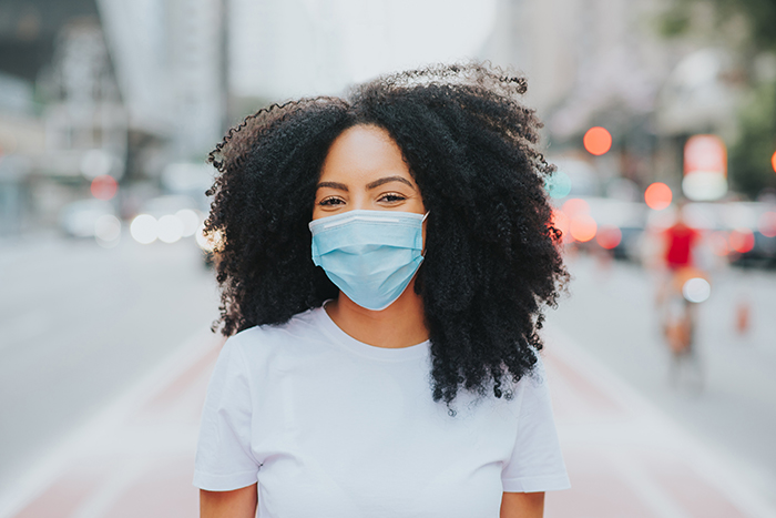 african-american woman wearing mask in public on busy street