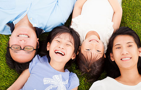 Family lying on grass and smiling