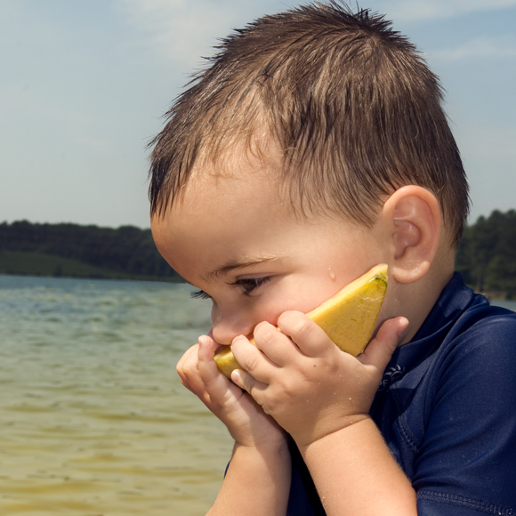 toddler eating a melon slice