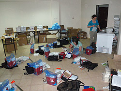 Colleen Martin and Danielle Rentz organize supplies for field workers. Later, they would turn this dusty room into a “laboratory,” complete with centrifuge and freezer.