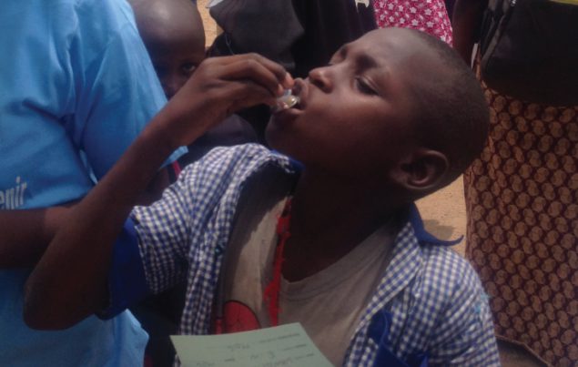 boy drinking a vaccine from a bottle