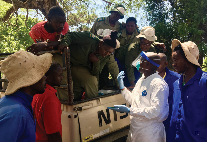 volunteers gather around a jeep