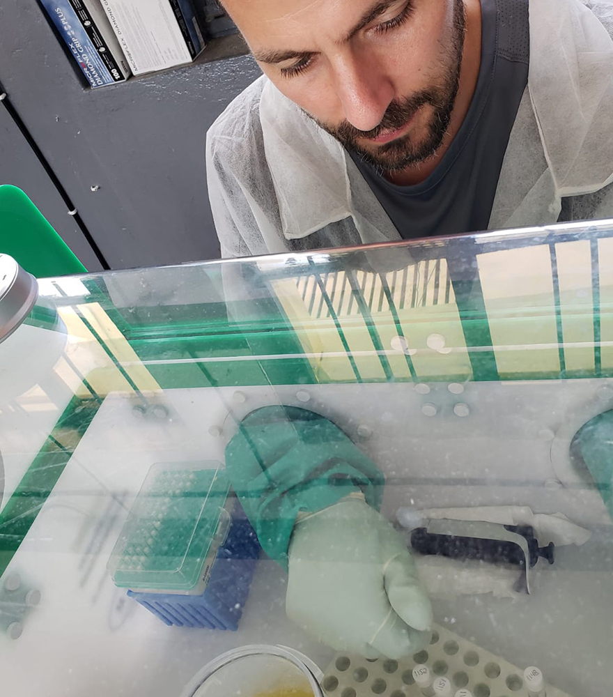 James Graziano using a piece of lab equipment called a glove box