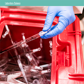 A scientist wearing gloves disposing of old lab equipment.