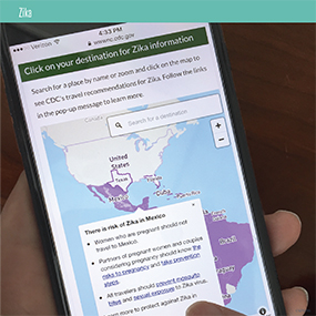 A person using a phone app to learn about zika infected areas.