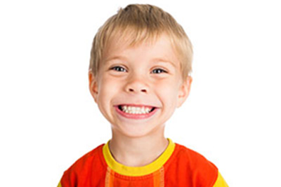 Image of young boy grinning with bright white teeth