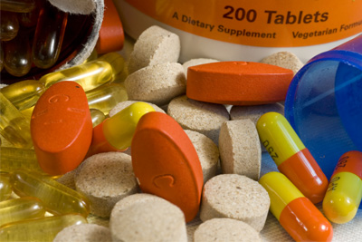 Image of colorful supplement pills with parts of pill bottles showing in the background