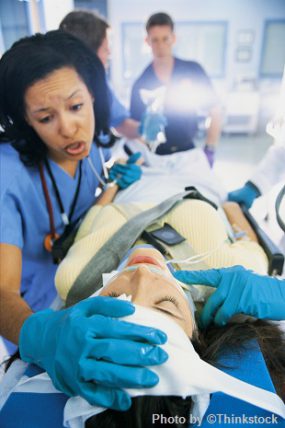 nurse assisting a patient lying on a gurney