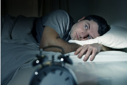 man lying in bed wide awake