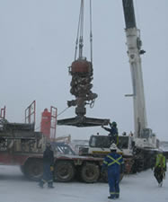 photo of workers outside using a crane with snow on the ground